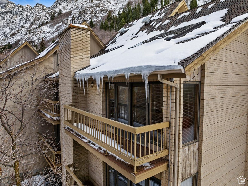 Snow covered property featuring a balcony