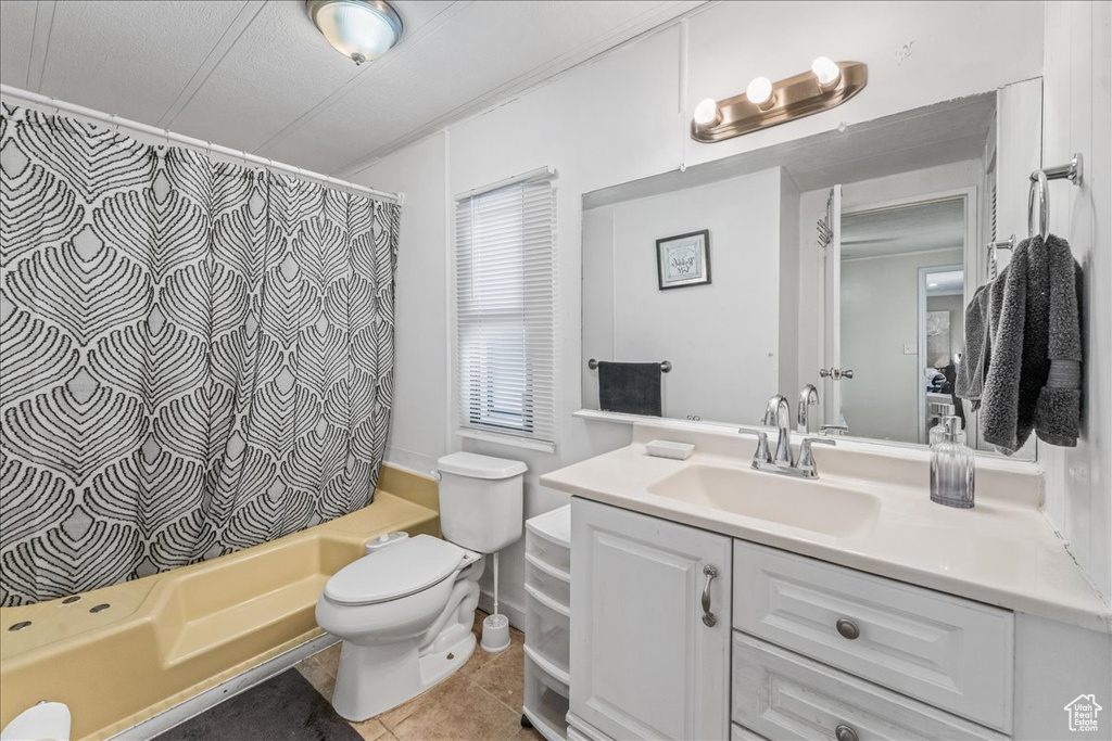 Full bathroom with oversized vanity, toilet, shower / bath combo, and tile flooring