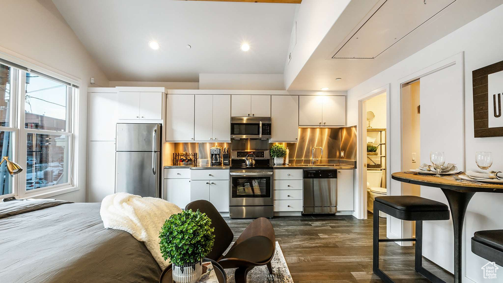Kitchen featuring tasteful backsplash, white cabinets, and stainless steel appliances