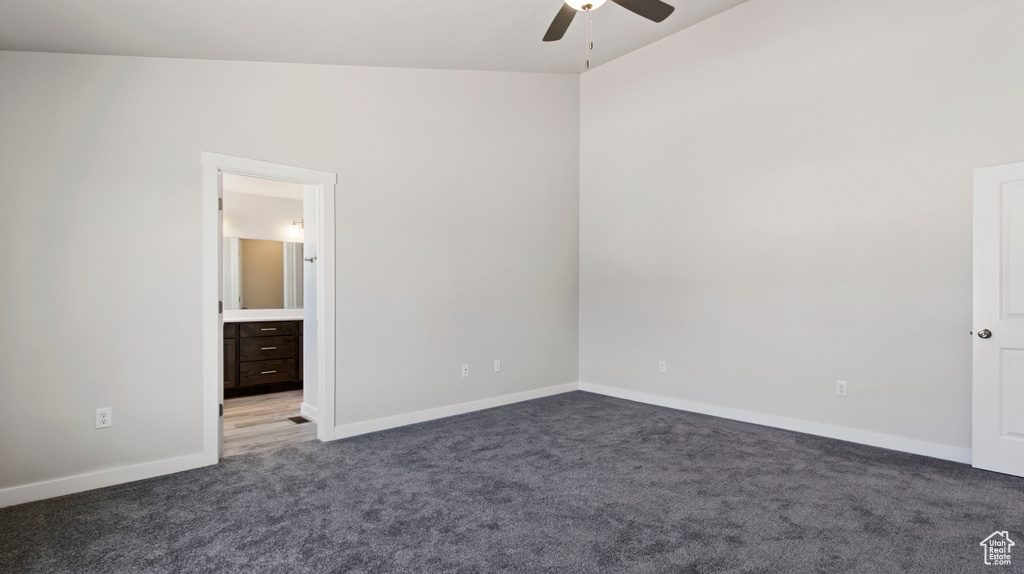 Carpeted empty room featuring lofted ceiling and ceiling fan