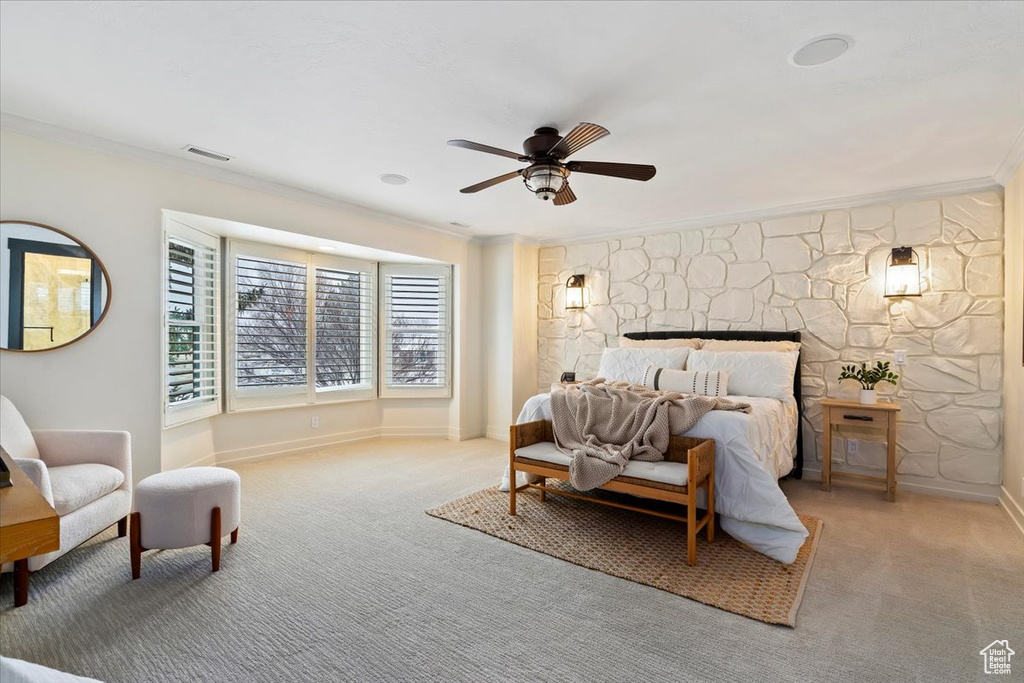 Carpeted bedroom featuring crown molding and ceiling fan