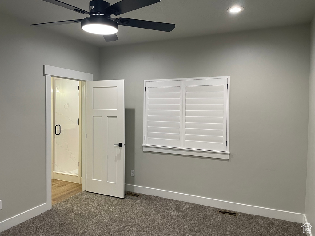 Empty room with hardwood / wood-style floors and ceiling fan
