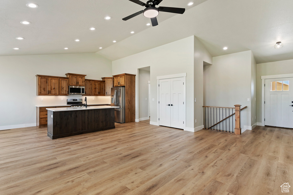 Kitchen featuring a center island with sink, light wood-type flooring, appliances with stainless steel finishes, and ceiling fan