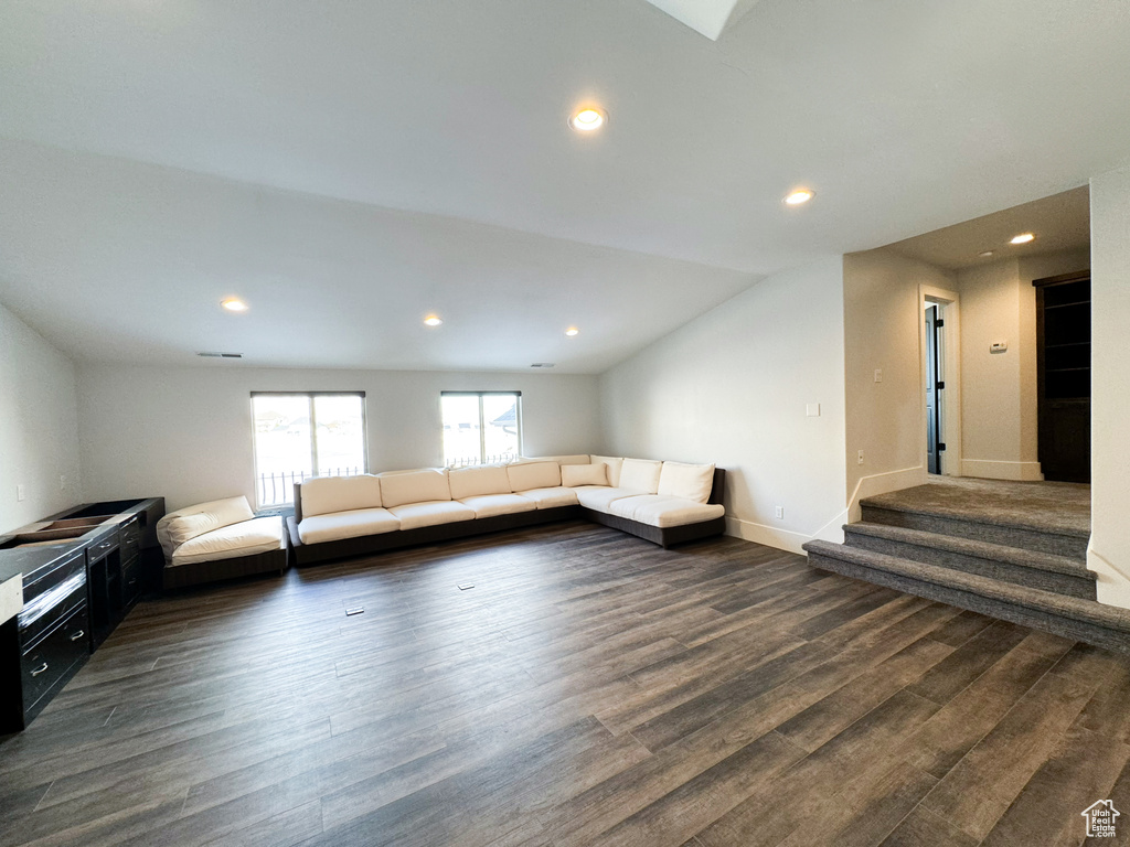 Additional living space with dark hardwood / wood-style floors and vaulted ceiling