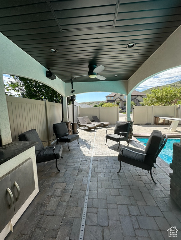 View of patio featuring a fenced in pool and ceiling fan