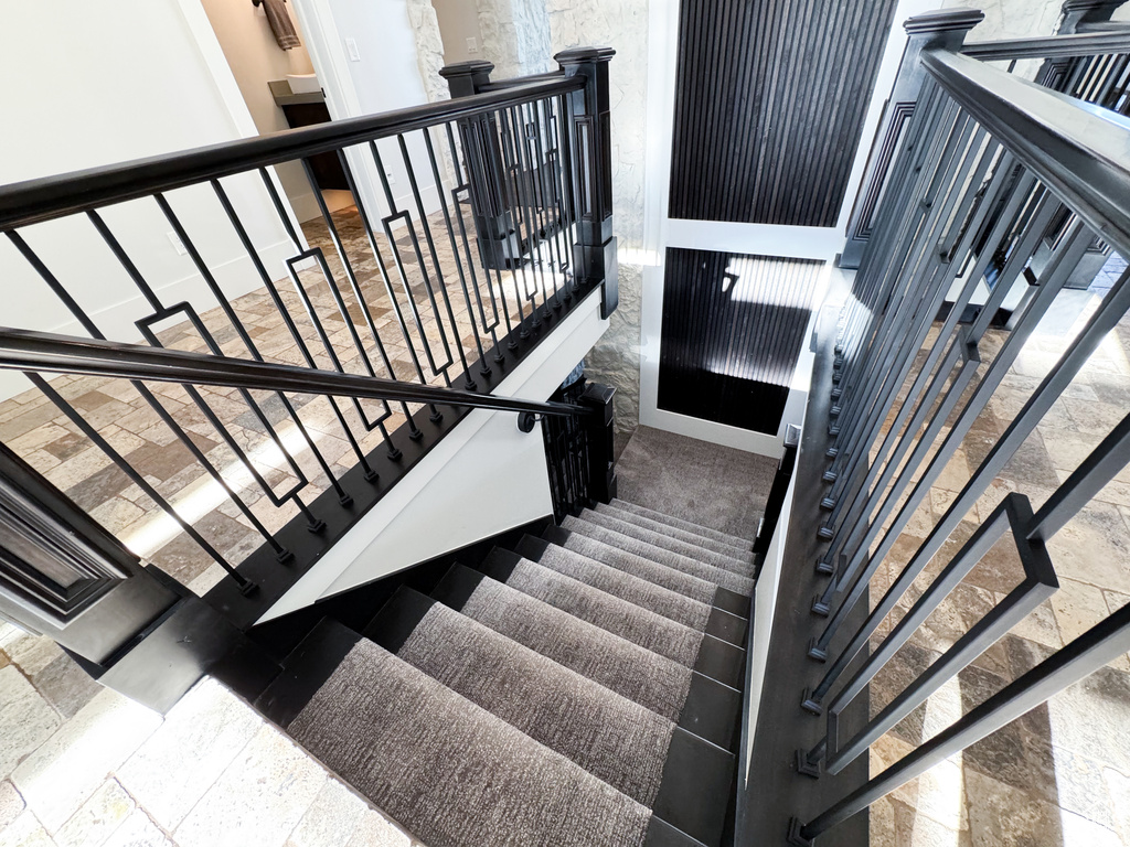 Staircase featuring dark tile flooring