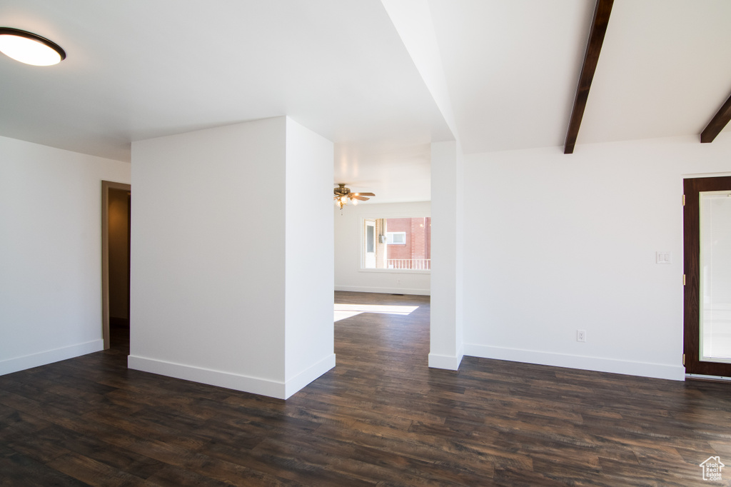 Unfurnished room with dark hardwood / wood-style flooring, ceiling fan, and beam ceiling