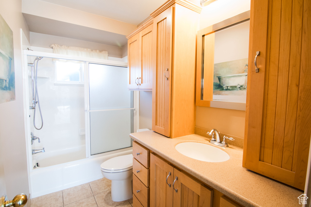 Full bathroom with enclosed tub / shower combo, tile flooring, oversized vanity, and toilet