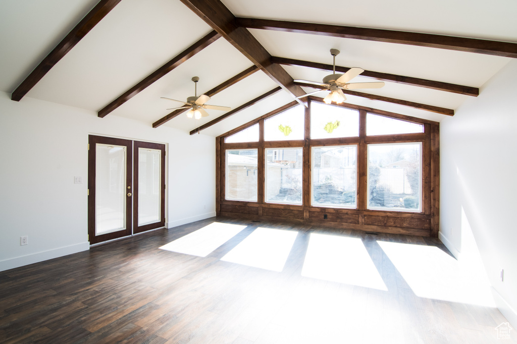 Spare room with dark hardwood / wood-style floors, ceiling fan, lofted ceiling with beams, and french doors
