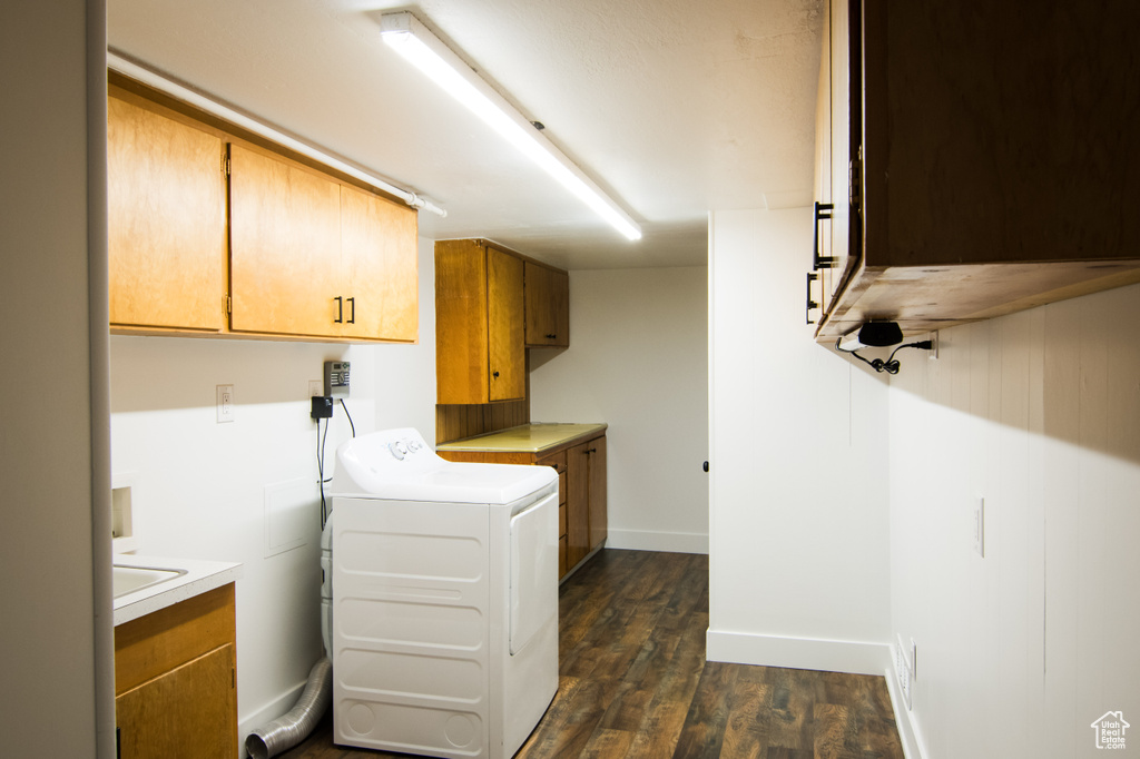 Washroom with washer / dryer, dark hardwood / wood-style flooring, and cabinets
