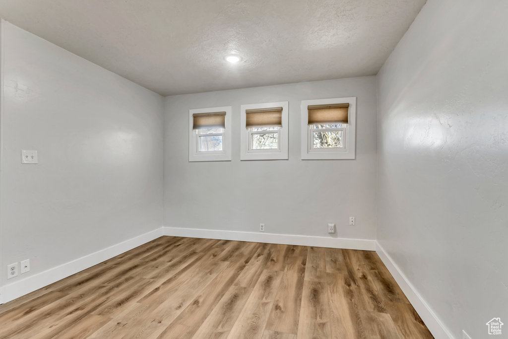 Empty room with light hardwood / wood-style floors and plenty of natural light