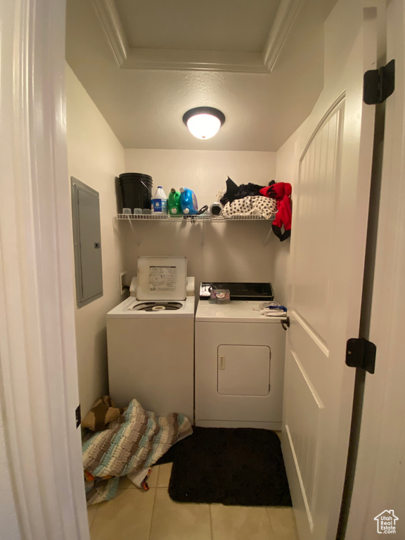 Washroom with ornamental molding, washer and dryer, tile flooring, and washer hookup