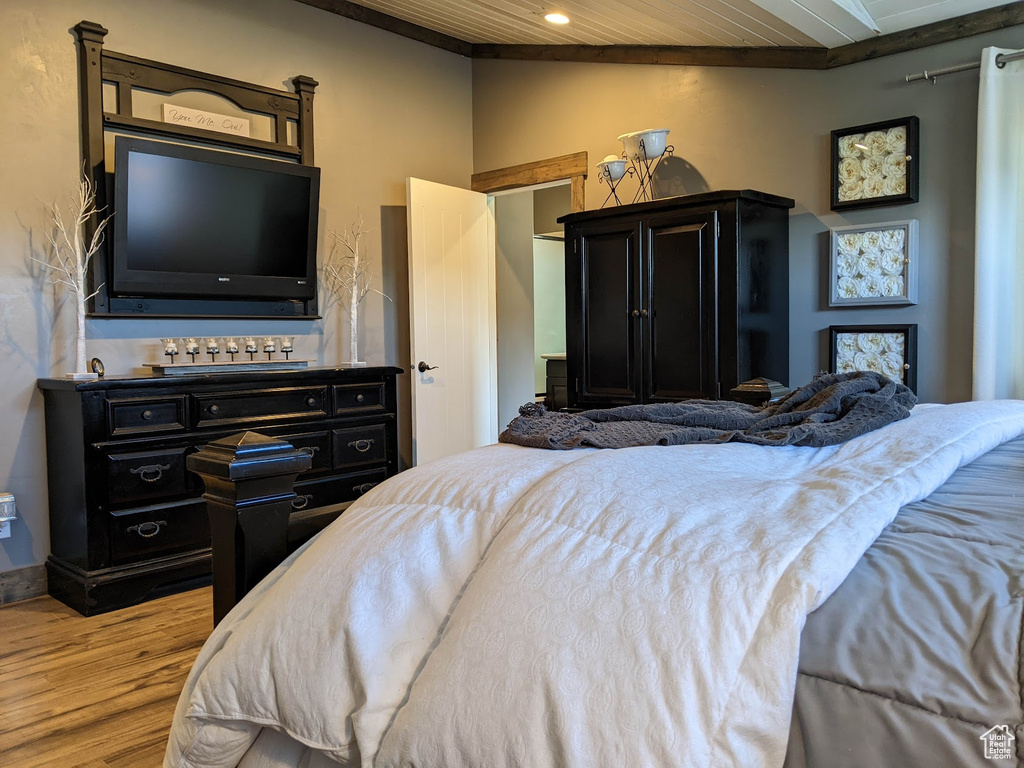 Bedroom featuring wood ceiling, light hardwood / wood-style floors, and ornamental molding