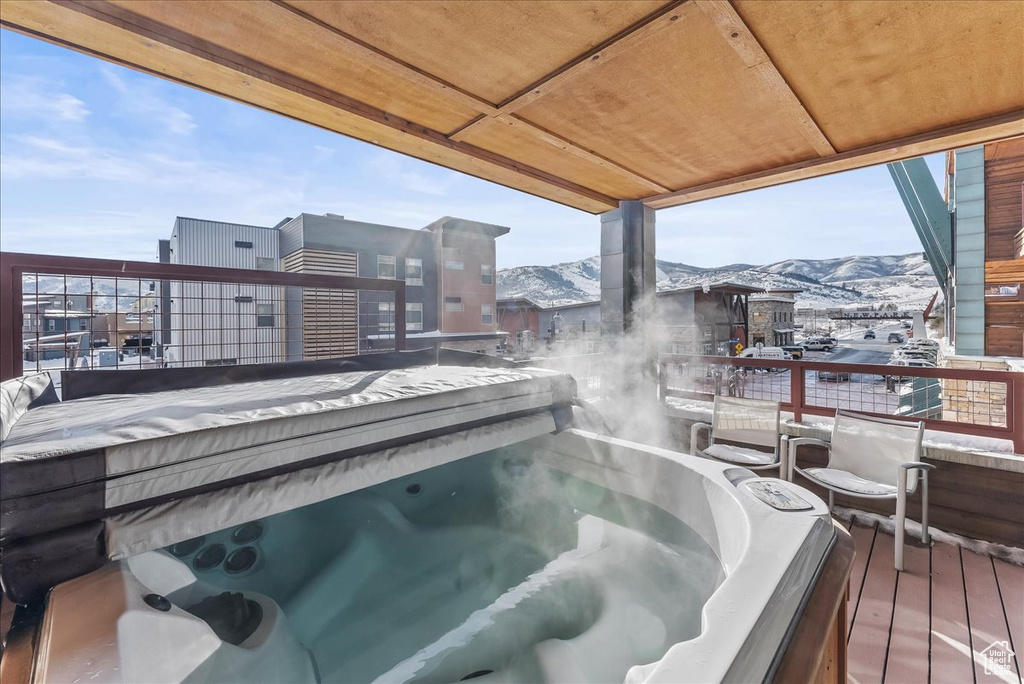 Exterior space with a covered hot tub and a mountain view