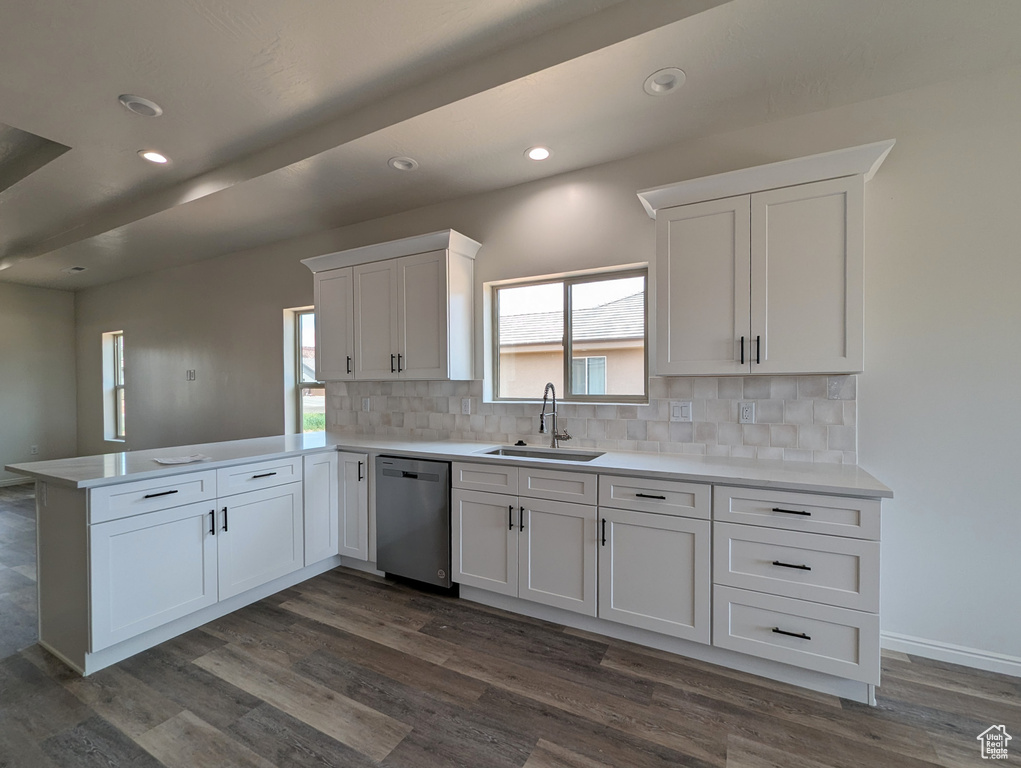 Kitchen with sink, tasteful backsplash, stainless steel dishwasher, dark hardwood / wood-style floors, and kitchen peninsula