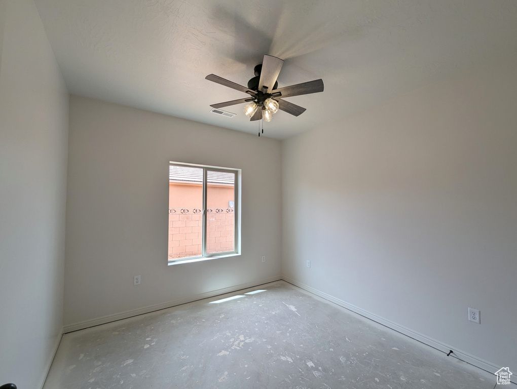 Unfurnished room featuring concrete flooring and ceiling fan