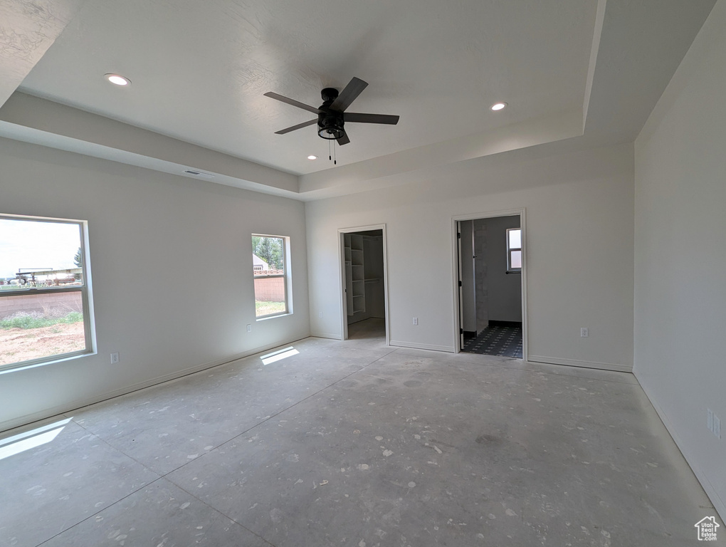 Unfurnished room featuring ceiling fan and a tray ceiling