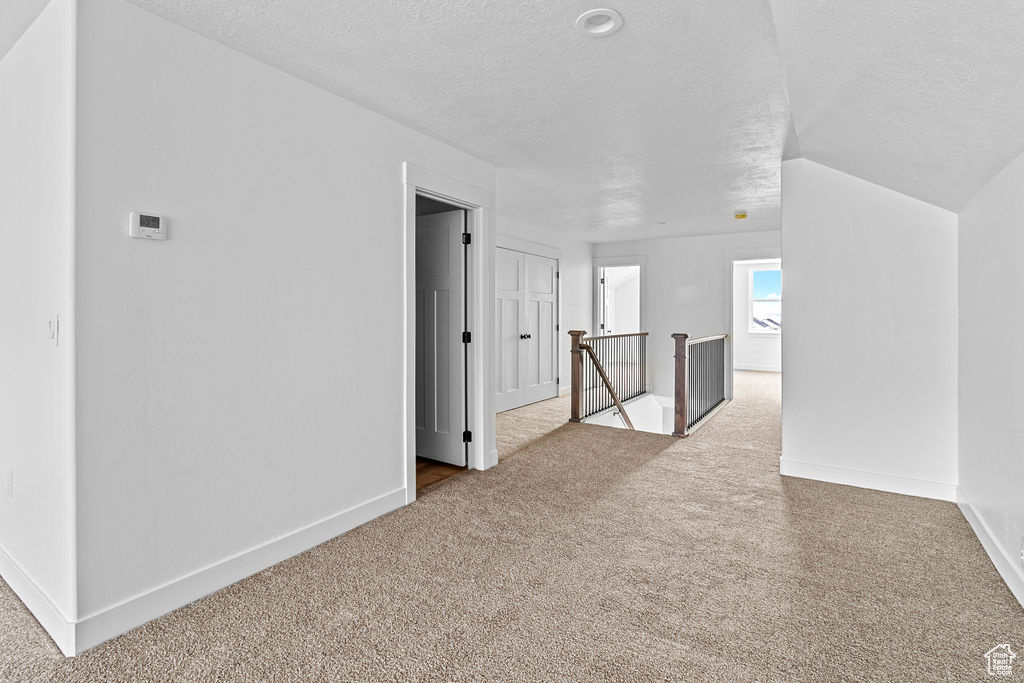 Spare room featuring light colored carpet and a textured ceiling
