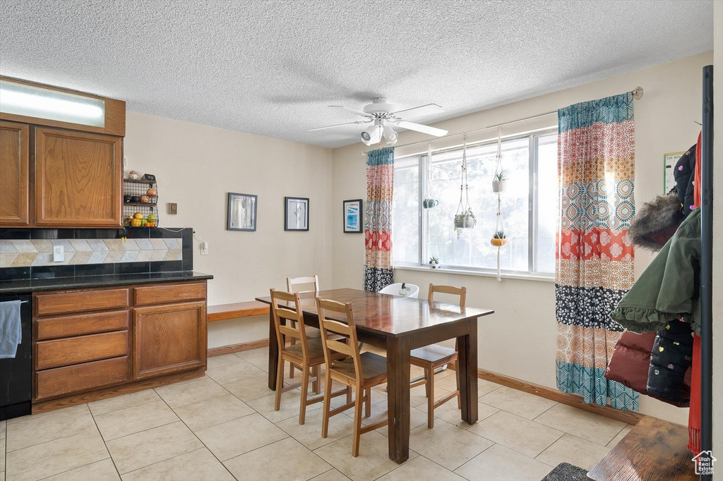 Tiled dining room featuring a textured ceiling and ceiling fan