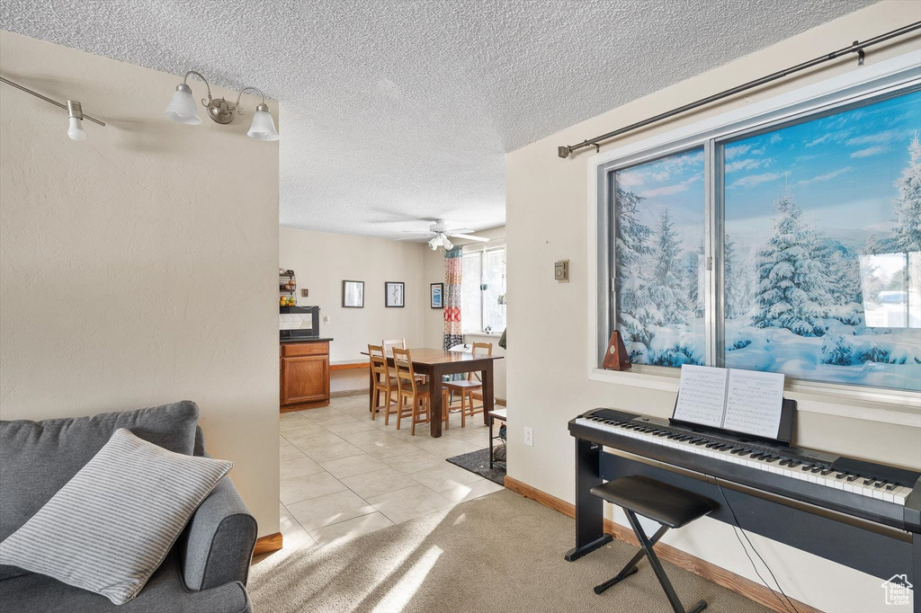 Misc room featuring light tile floors, a textured ceiling, and ceiling fan