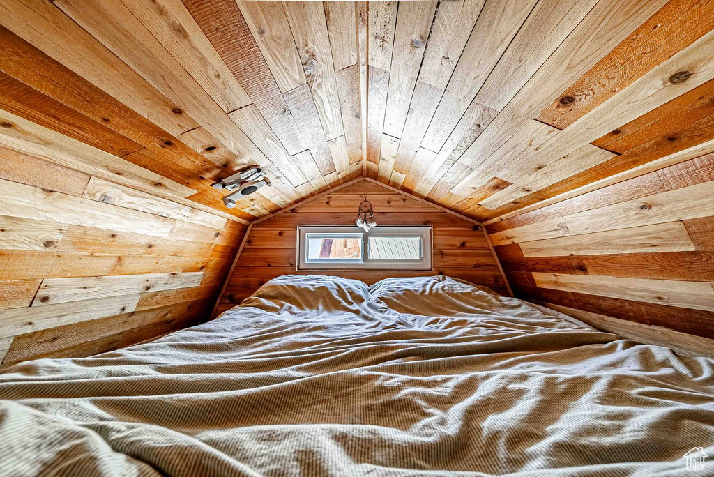 Unfurnished bedroom featuring vaulted ceiling and wooden ceiling