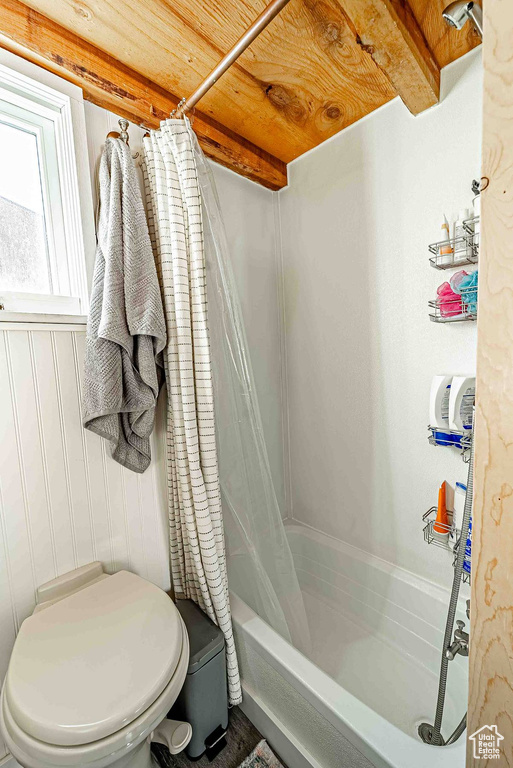Bathroom featuring shower / tub combo with curtain, toilet, and wood ceiling