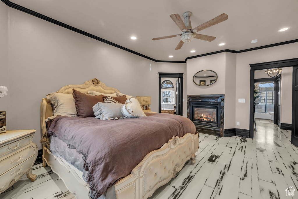 Bedroom with ornamental molding, light wood-type flooring, and ceiling fan