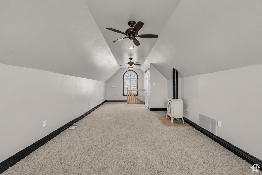 Bonus room with light carpet, vaulted ceiling, and ceiling fan