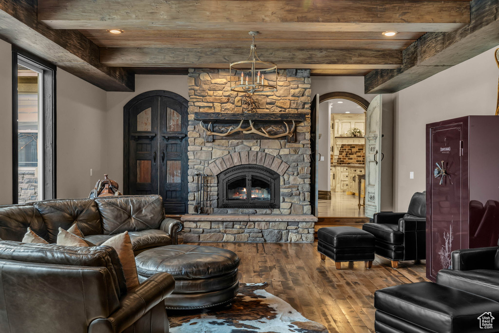 Living room featuring beam ceiling, a fireplace, and dark hardwood / wood-style floors