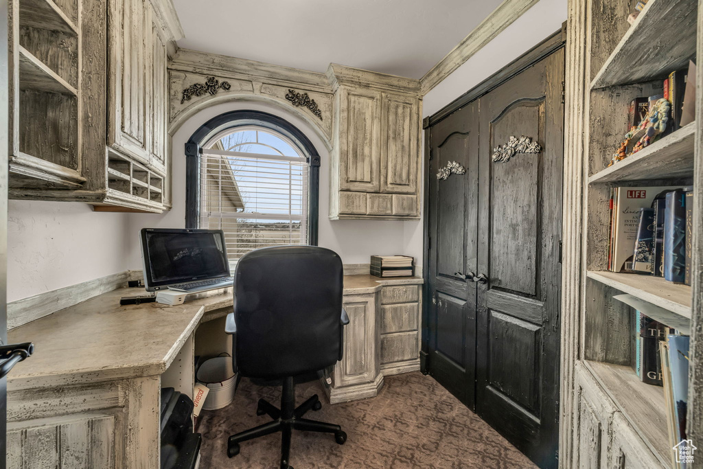Office area with ornamental molding and built in desk