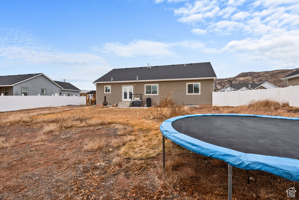 Back of property featuring a trampoline