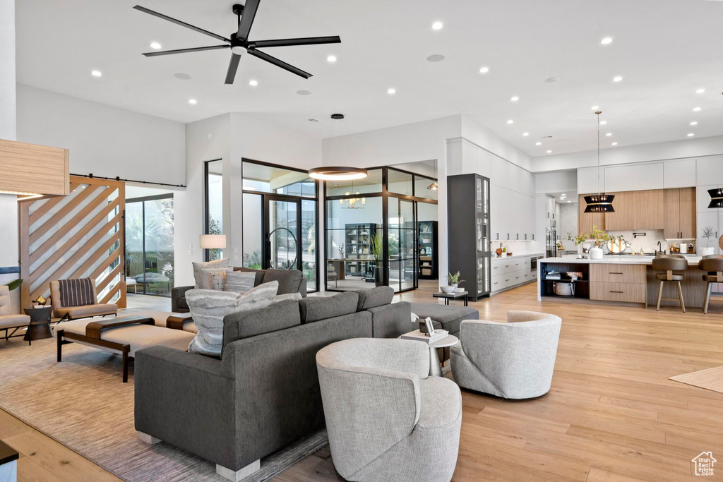 Living room featuring light hardwood / wood-style floors and ceiling fan with notable chandelier