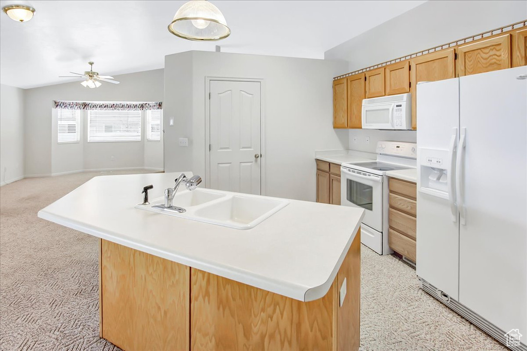 Kitchen featuring light carpet, white appliances, ceiling fan, sink, and a kitchen island with sink
