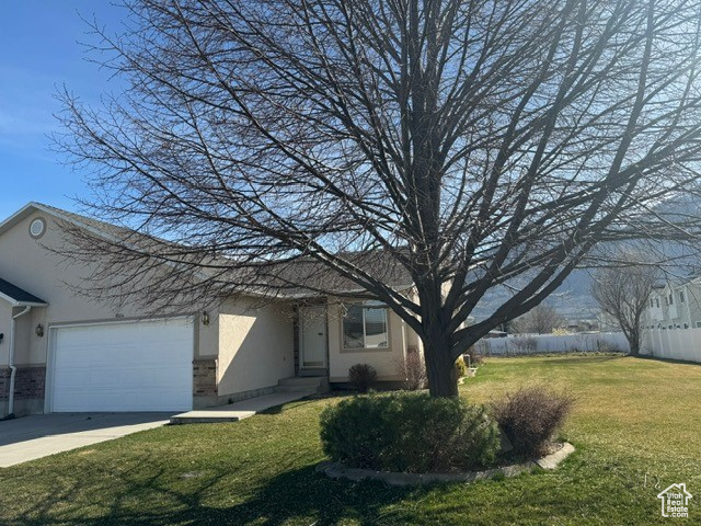View of front of home with a front yard and a garage