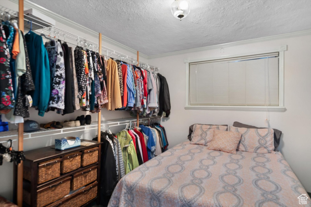 Bedroom featuring ornamental molding and a textured ceiling