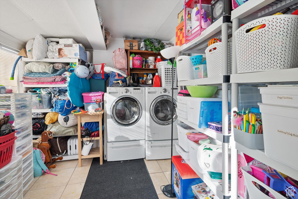 Clothes washing area featuring separate washer and dryer and light tile floors