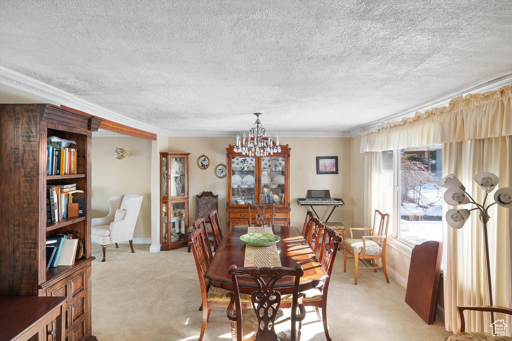 Carpeted dining room featuring crown molding, a notable chandelier, and a textured ceiling