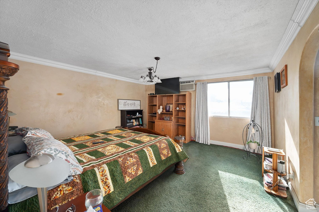 Bedroom with crown molding, dark carpet, ceiling fan with notable chandelier, a textured ceiling, and an AC wall unit