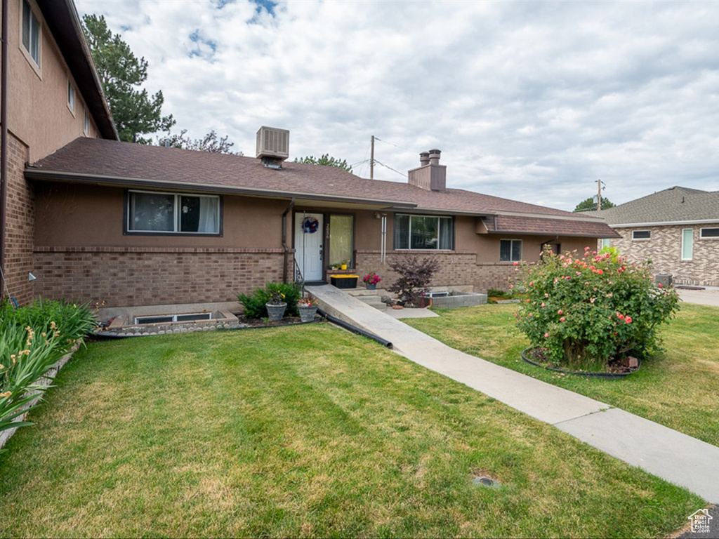 Single story home featuring a front lawn