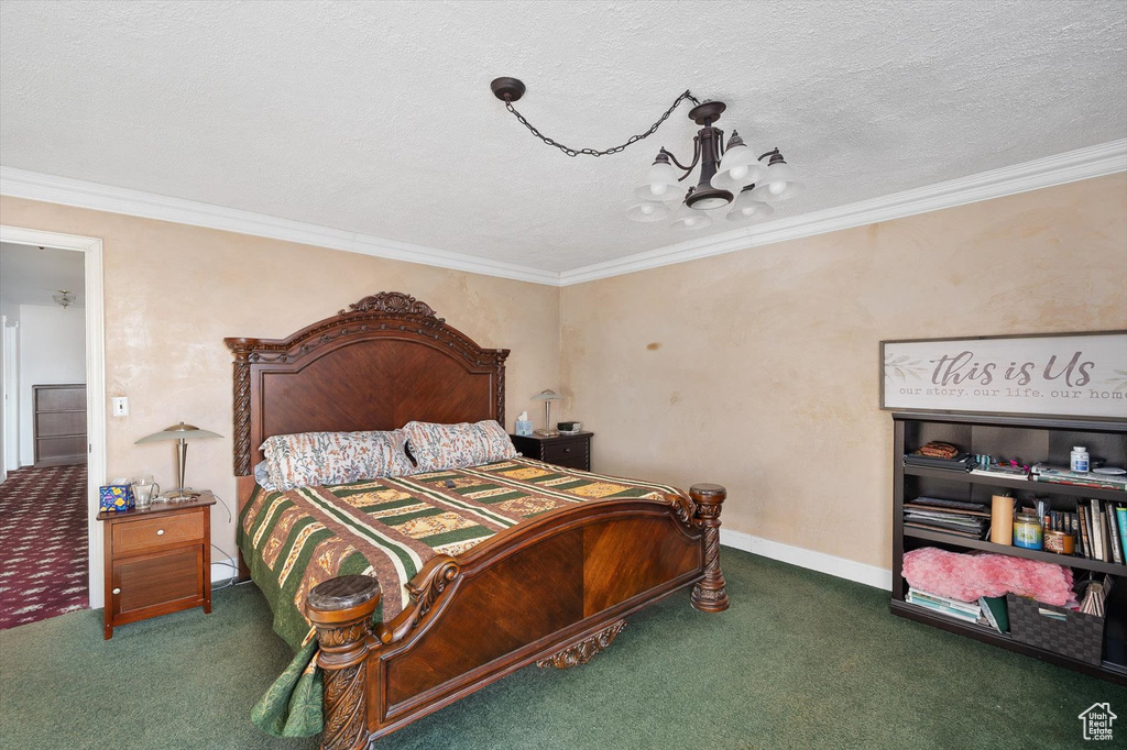 Bedroom featuring ornamental molding, dark carpet, an inviting chandelier, and a textured ceiling