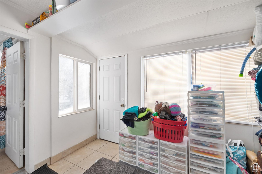 Interior space featuring vaulted ceiling, light tile floors, and plenty of natural light