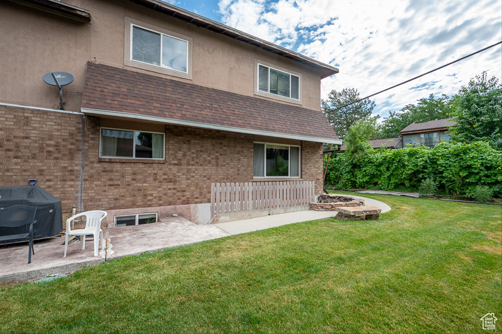 Back of property featuring a patio area and a yard