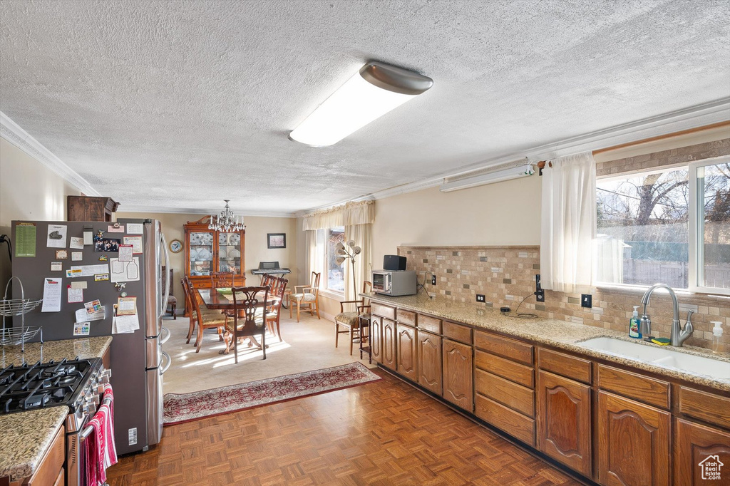 Kitchen featuring a chandelier, backsplash, dark parquet floors, sink, and a textured ceiling