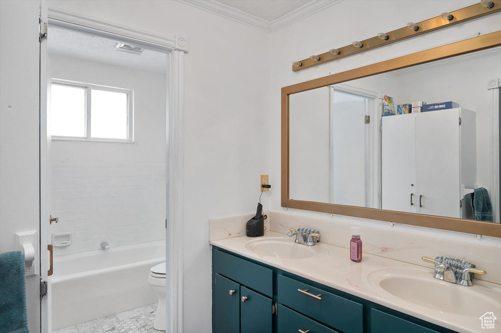 Bathroom with crown molding, dual sinks, tile floors, toilet, and vanity with extensive cabinet space
