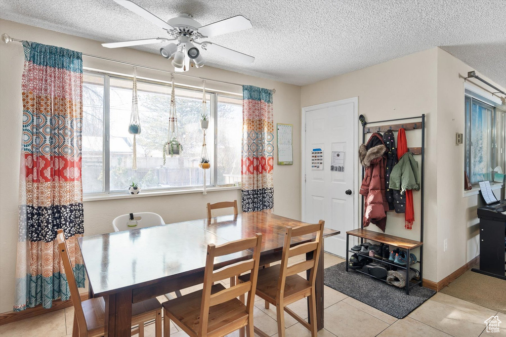 Tiled dining room with a textured ceiling and ceiling fan