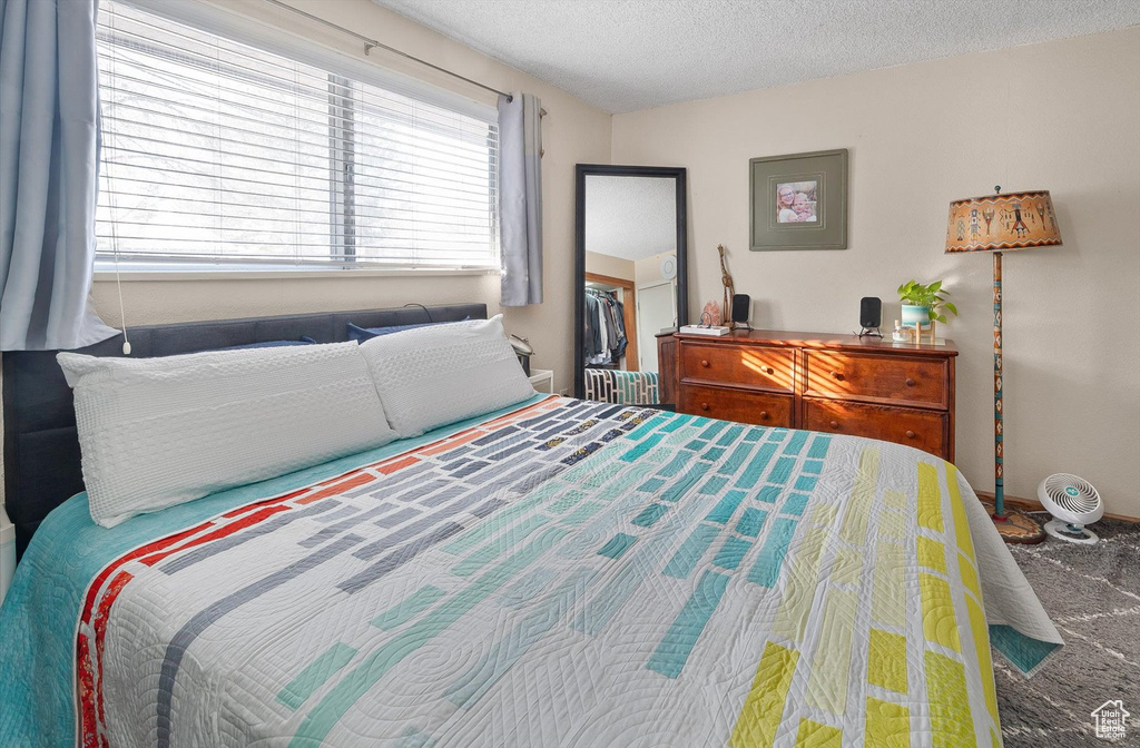 Bedroom featuring carpet floors and a textured ceiling