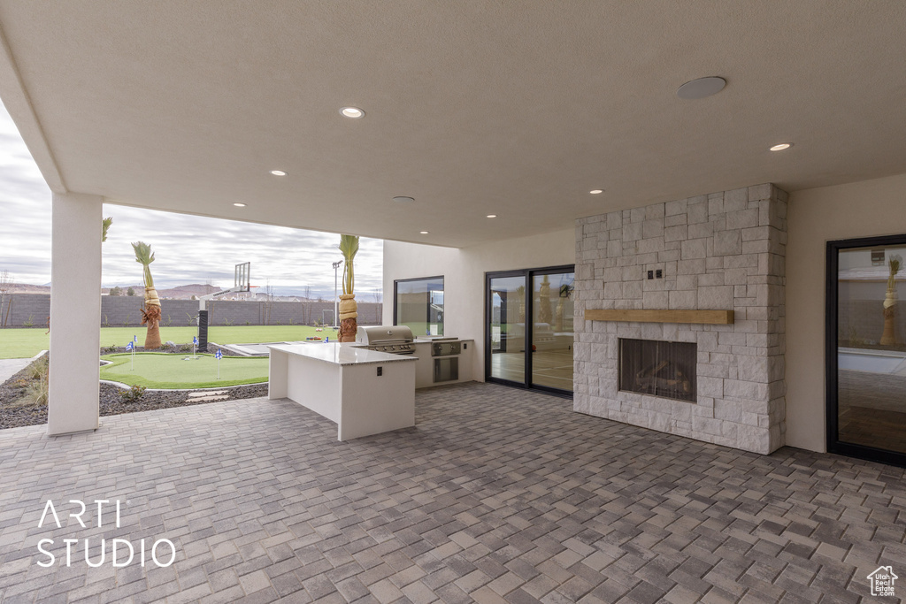 View of terrace with an outdoor kitchen, a fireplace, and a grill