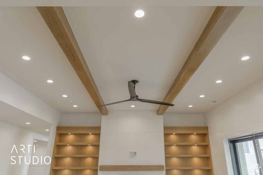 Details with beam ceiling, built in features, and ceiling fan