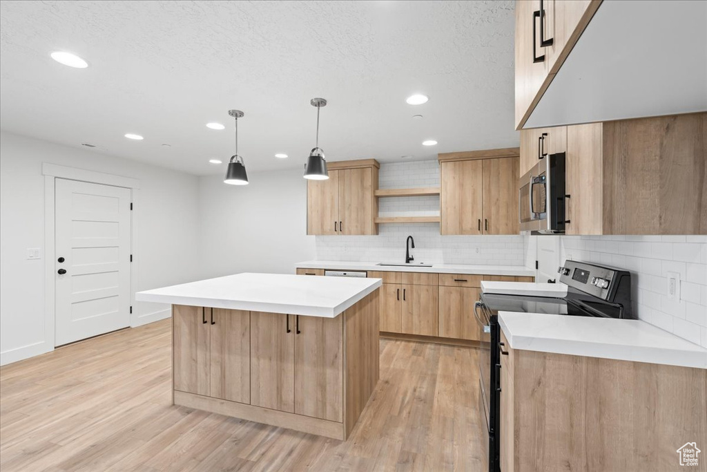 Kitchen with light hardwood / wood-style floors, tasteful backsplash, decorative light fixtures, electric stove, and a center island
