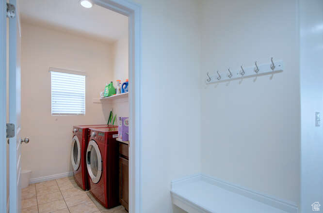 Clothes washing area with washing machine and clothes dryer and light tile floors